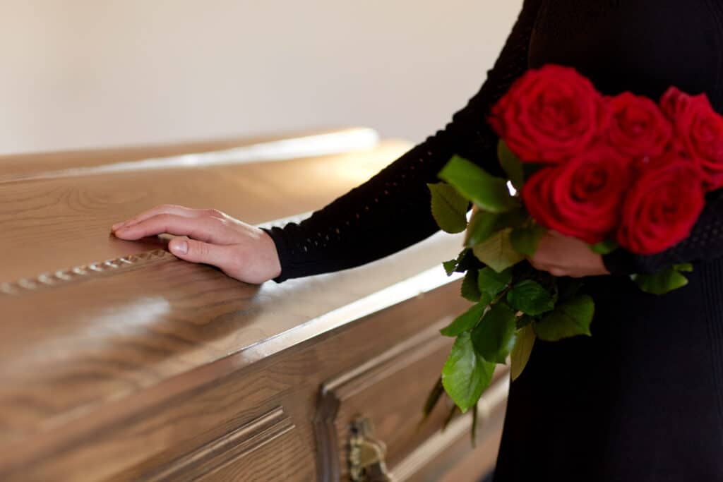 people mourning concept woman with red roses coffin funeral church